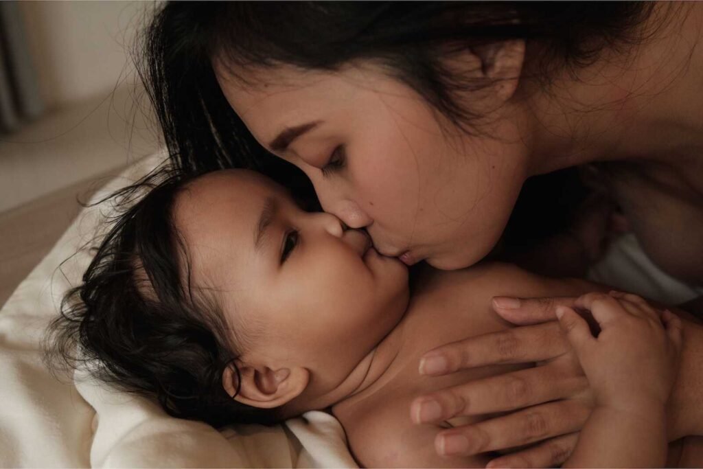 Close-up of mom kissing baby during a tender mom and baby photoshoot.