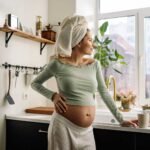 Pregnant woman in a bright kitchen practicing self-care with holistic pregnancy tips.